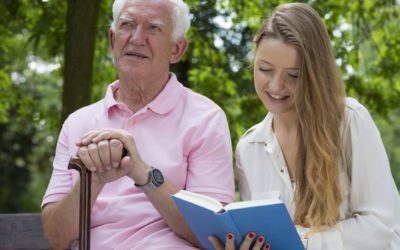 Caregiver reading to elderly patient