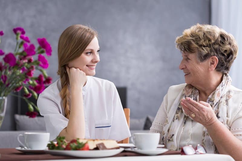 Cargiver conversing with elderly patient