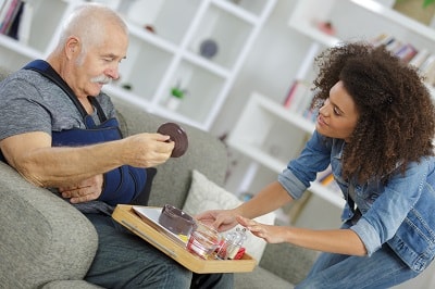 Caregiver helping patient with arm injury