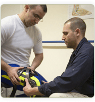 patient with knee brace and a physical therapist