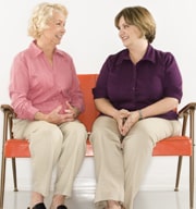 two ladies sitting on orange couch