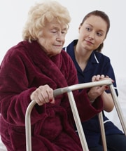 elder patient with walking aid assisted by nurse