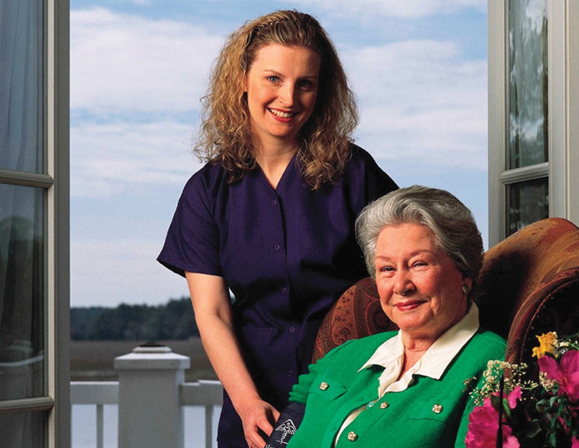 elder patient with walking aid assisted by nurse