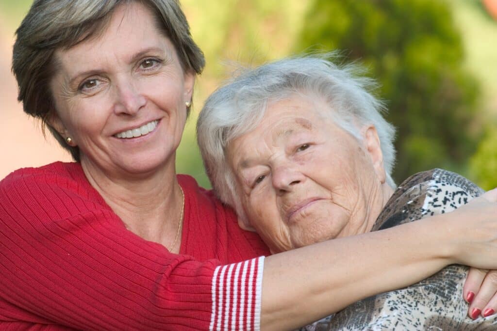 Caregiver hugging elderly patient