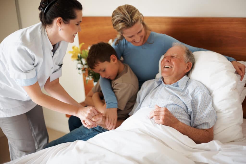 Elderly patient with Parkinson's disease lying down in bed with family and caregiver