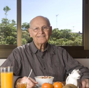 Elderly man eating a healthy breakfast at home