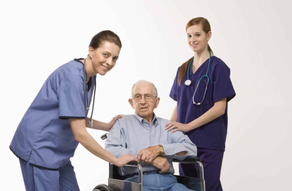 Nurses taking care of elderly person on a wheelchair