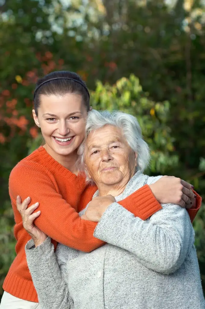 A young woman hugging her elderly grandmother