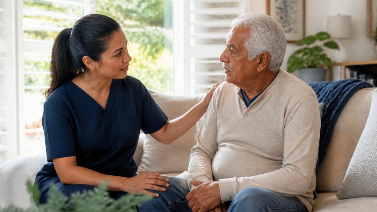 Professional caregiver speaking gently to older adult in comfortable home setting with soft natural lighting, maintaining relaxed body language and eye contact